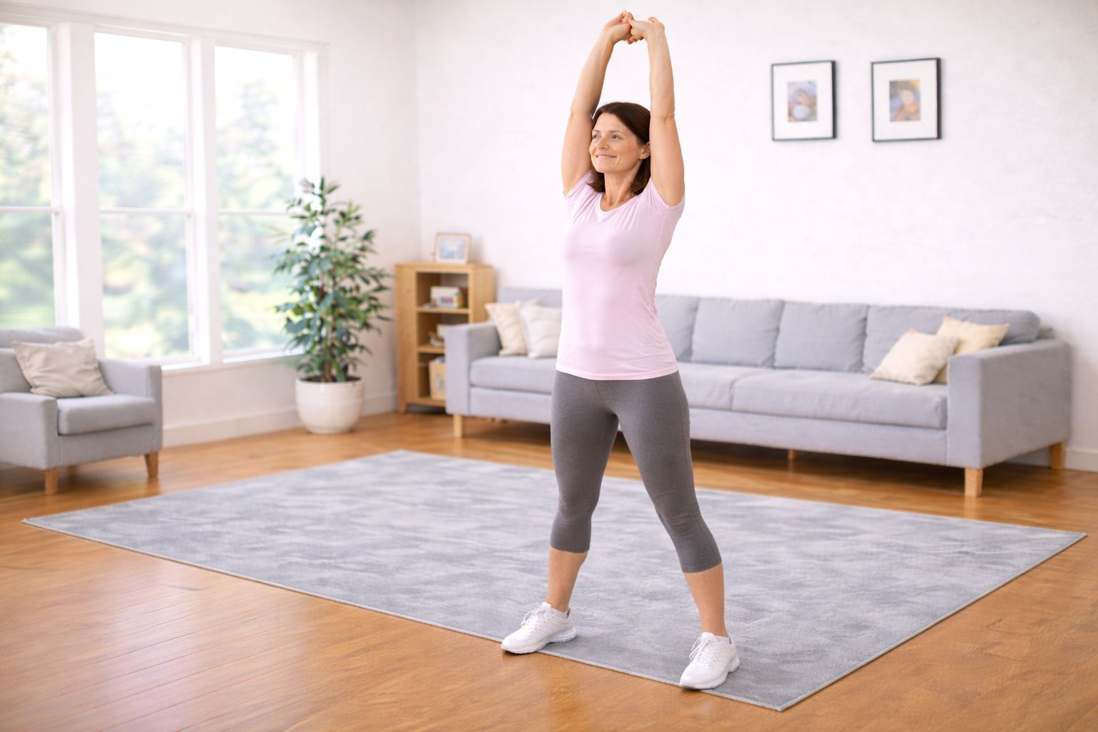 A person reaching arms overhead while stretching the upper body in a calm home setting.